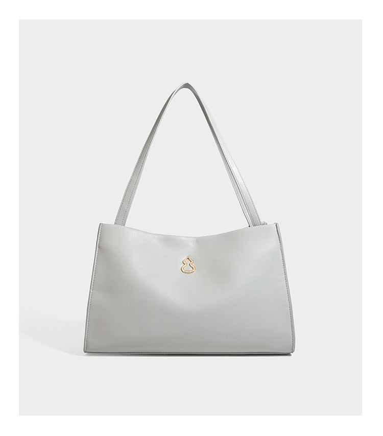 Structured rectangular shoulder tote bag with smooth leather-look finish, long double straps, and gold-tone gourd emblem on