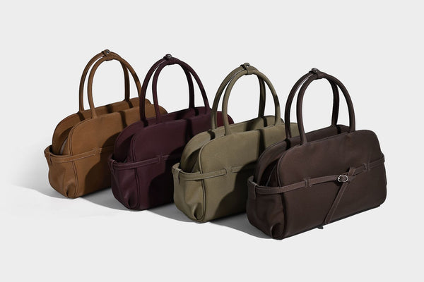 Strukturierte Henkeltasche aus mattem, genarbtem Material mit umlaufendem Riemen und Ringbeschlägen, zwei oberen Tragegriffen und abnehmbarem Crossbody-Riemen