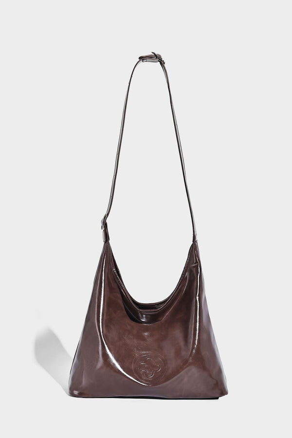 Glossy slouchy hobo shoulder bag with adjustable strap and embossed floral emblem, detail view 25