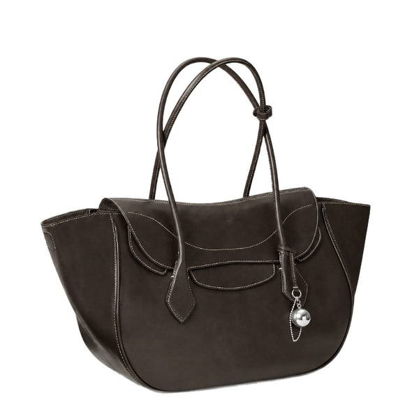 Large winged leather-look tote bag with single arched handle, stitched flap-front panel, and silver ball charm in cognac