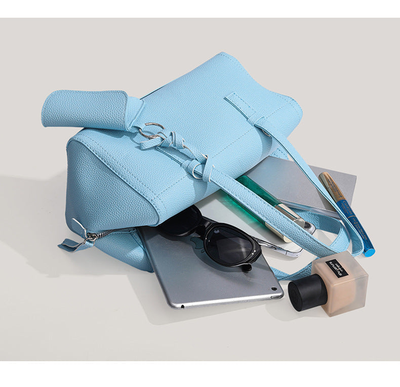 Light blue pebbled matte Boston tote bag with top handles, detachable shoulder strap, metal ring hardware, and matching mini
