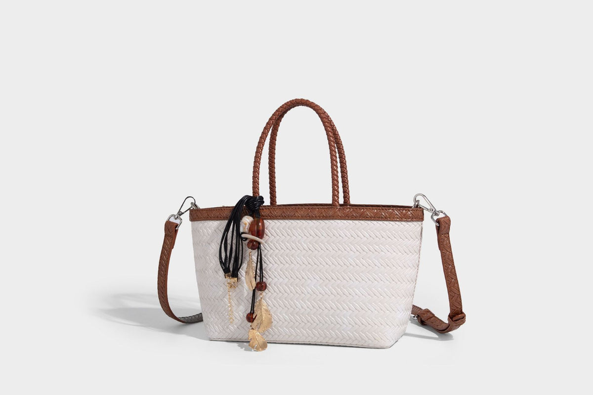 Structured chevron woven leather-look tote bag with braided top handles, gold feather charm, and adjustable shoulder strap