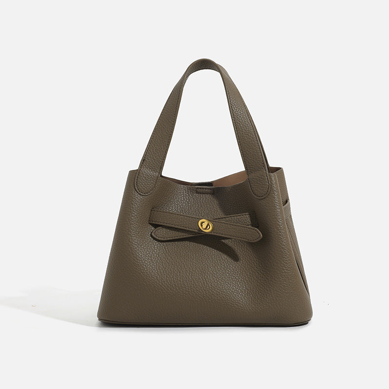 Pebbled trapezoid tote bag with gold turn-lock strap detail and matching snap pouch, detail view 6