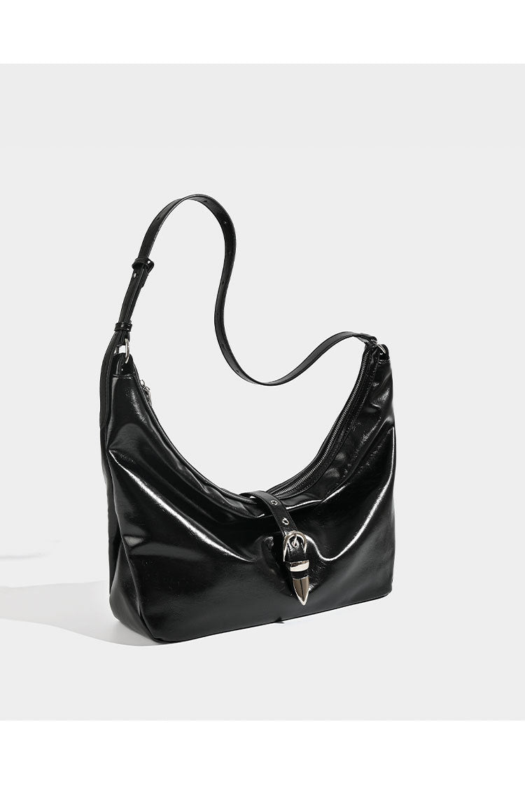 Slouchy crescent hobo bag with glossy leather-look finish, silver-tone buckle hardware, and flat shoulder strap, detail view