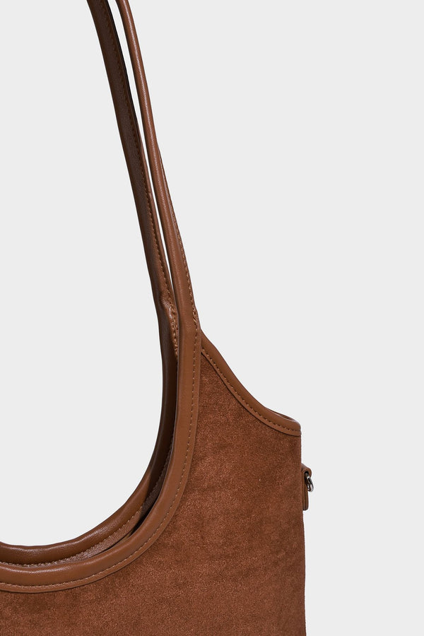 Tote-Bag in warmem Braun mit matter Wildlederoptik, langen Tragegriffen, geprägtem Logo, silberfarbenen Beschlägen und passendem, Detail
