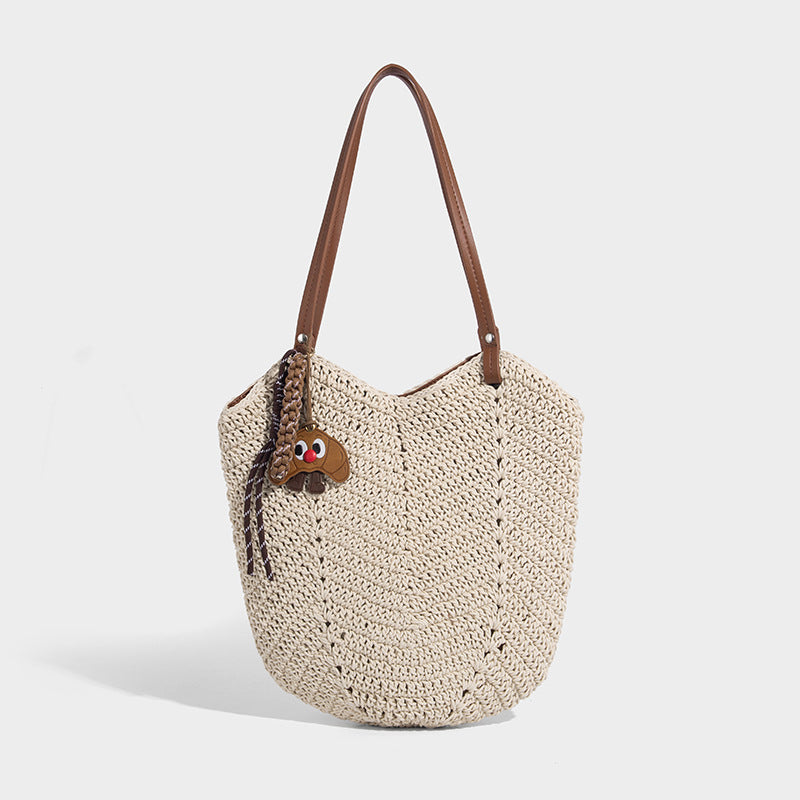 Woven crochet open-top shoulder tote bag with slim brown leather-look straps and braided charm accent, front view