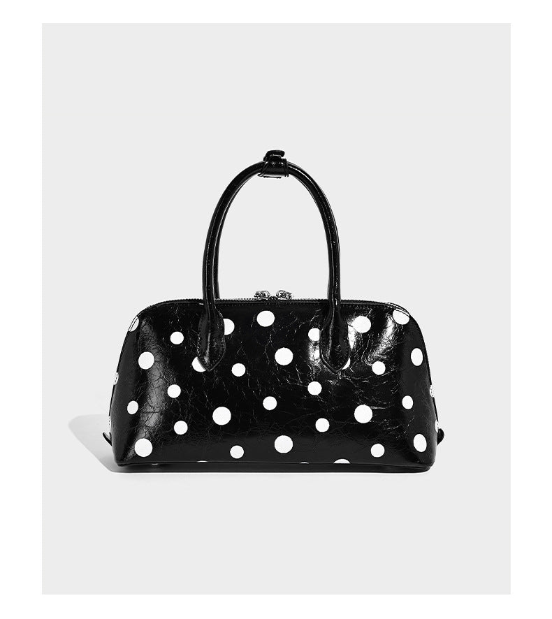 Structured polka-dot Boston bag with glossy crinkled finish, dual top handles, silver-tone turn-lock clasp, and detachable