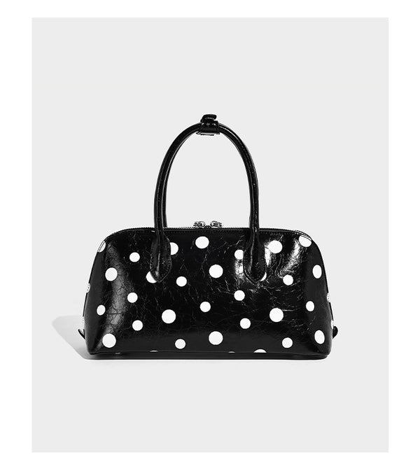 Structured polka-dot Boston bag with glossy crinkled finish, dual top handles, silver-tone turn-lock clasp, and detachable