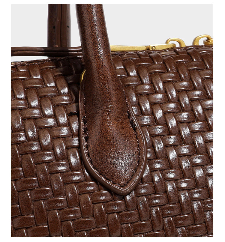 Structured woven-embossed leather-look satchel with dual rolled top handles, gold-tone turn-lock closure, and detachable