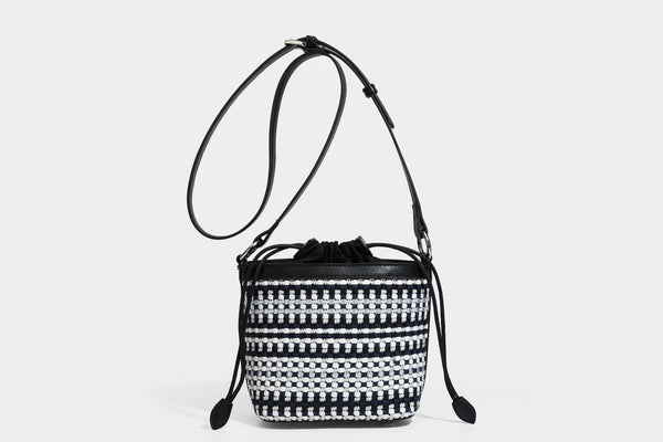 Small structured woven checker bucket bag with braided top handle, drawstring closure, and silver-tone hardware in black