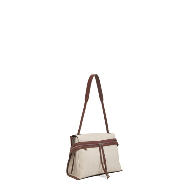 Cream canvas tote bag with brown leather-look trim, dual exterior zip pockets, long shoulder strap, and black flower charm