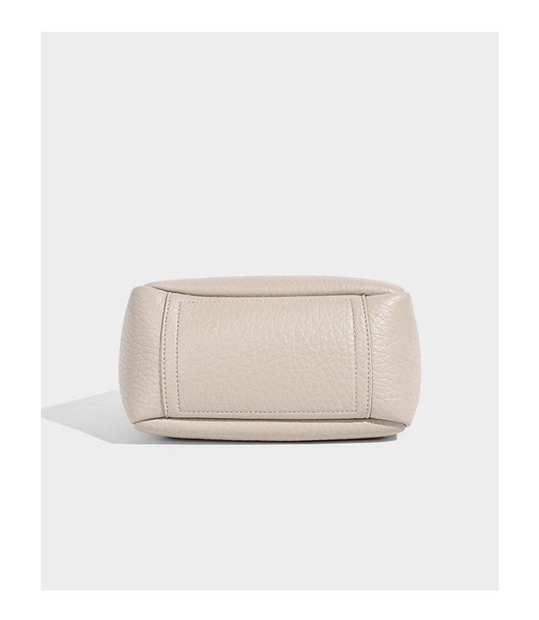 Small structured pebbled bucket tote with double top handles, silver turn-lock hardware, and detachable shoulder strap