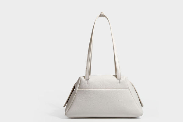 Structured trapezoid shoulder bag in dark brown pebbled leather-look finish with slim double straps, top zip closure, side