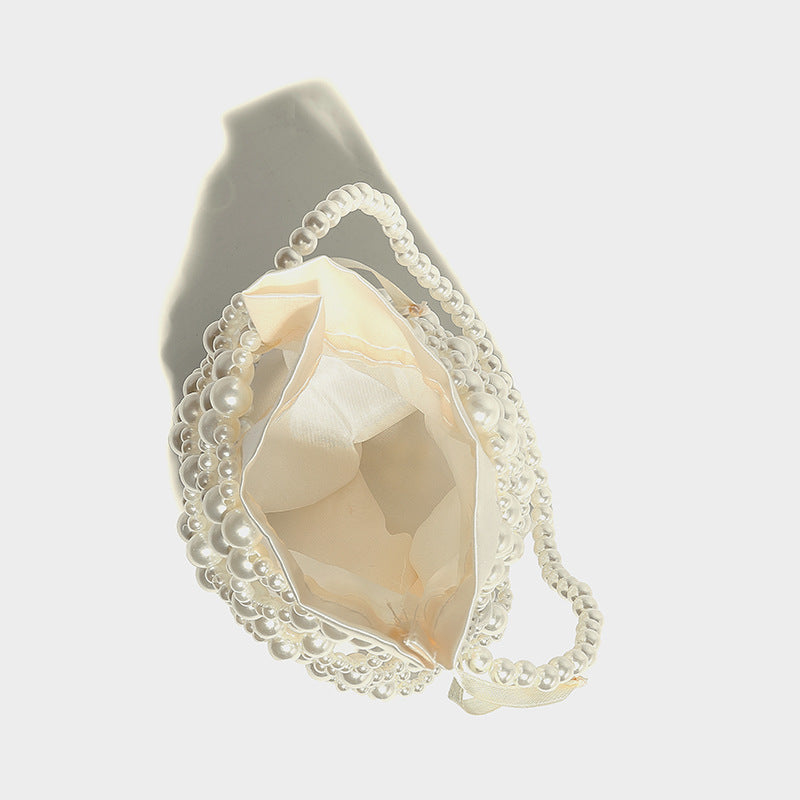Small pearl-beaded lattice drawstring bucket bag with beaded shoulder strap and ribbon closure, detail view 24