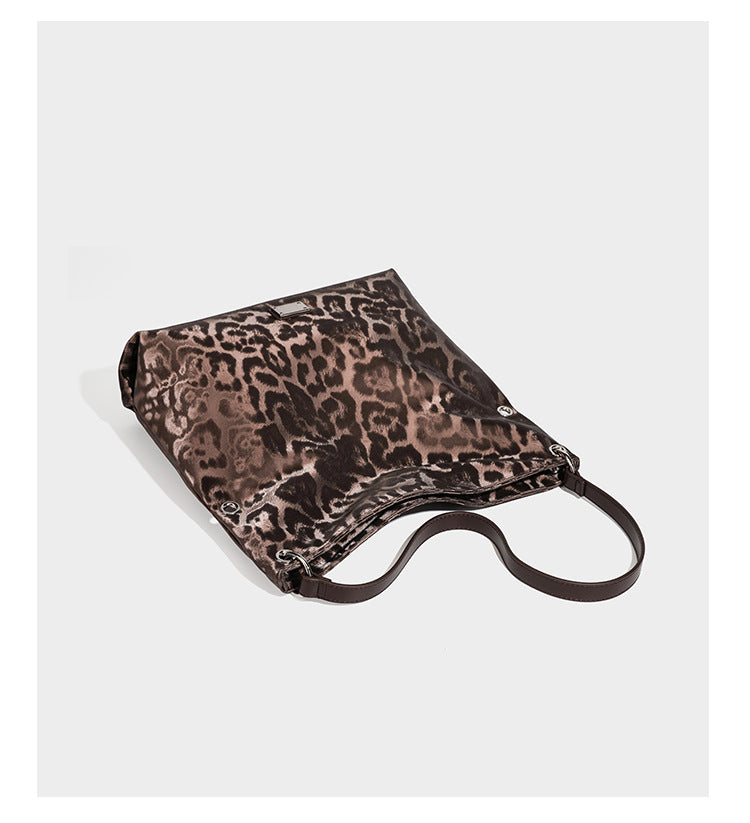 Lässige Hobo-Schultertasche mit Leopardenmuster, glänzender Satinoptik, silberfarbenen Ringbeschlägen und schmalem Schulterriemen