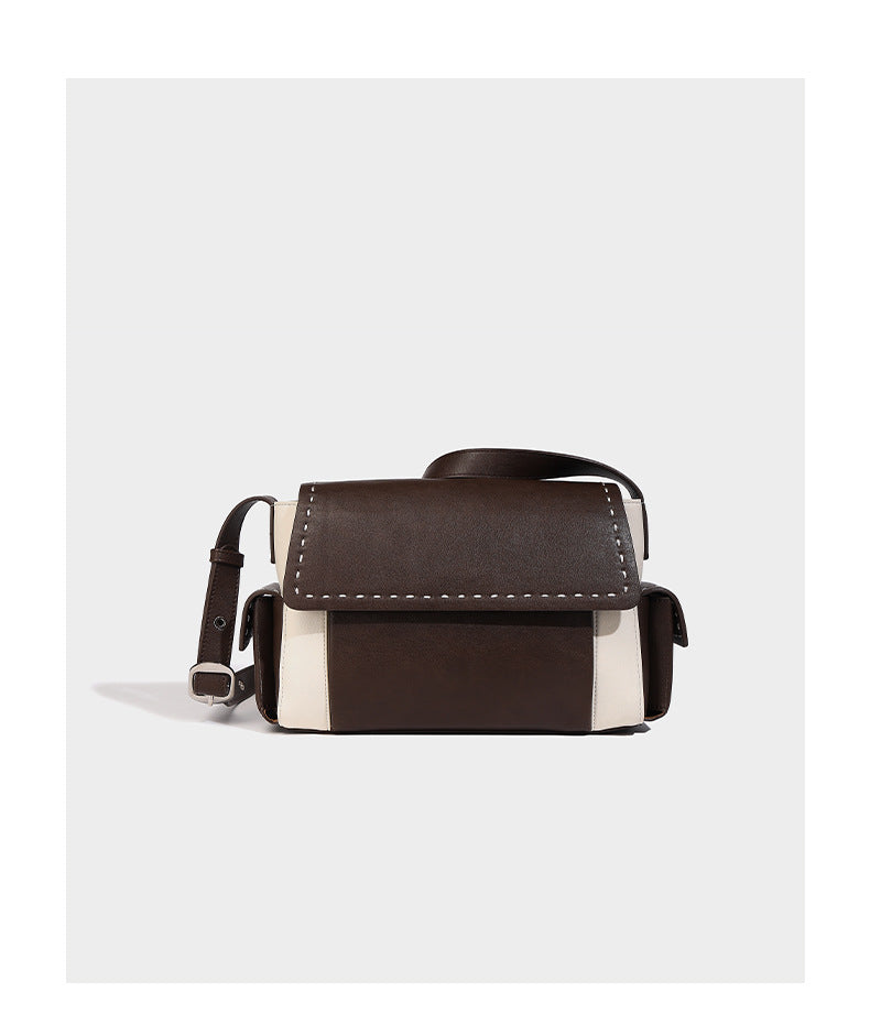Structured flap crossbody bag in dark brown and cream color-block with white contrast stitching, adjustable shoulder strap