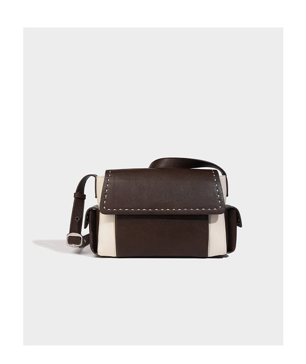 Structured flap crossbody bag in dark brown and cream color-block with white contrast stitching, adjustable shoulder strap