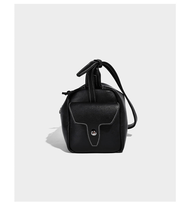 Small slouchy moto-style crossbody bag in smooth matte leather-look finish with white contrast stitching, silver-tone, detail