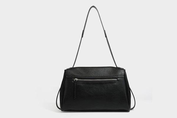 Strukturierte rechteckige dunkelbraune Schultertasche in Lederoptik mit Klappe, mehrlagigem Detail auf der Vorderseite und langem verstellbarem Riemen, Detailansicht