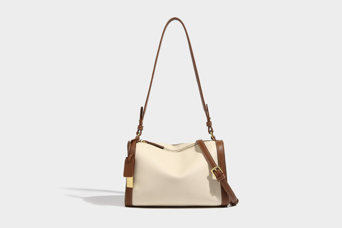 Structured two-tone shoulder bag with pebbled leather-look finish, contrast trim, top zip closure, and gold-tone hardware