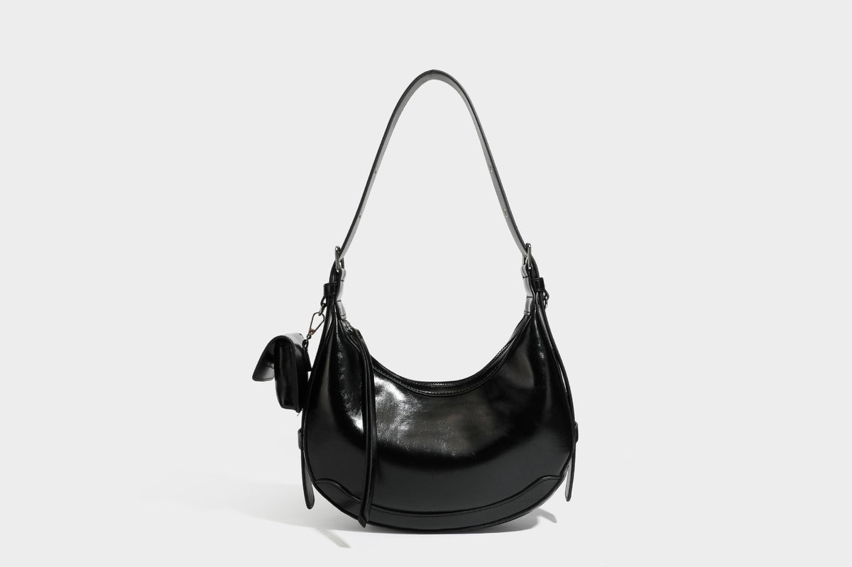 Glossy leather-look crescent hobo shoulder bag with dark contrast trim, silver-tone hardware, and attached mini flap pouch