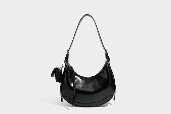 Glossy leather-look crescent hobo shoulder bag with dark contrast trim, silver-tone hardware, and attached mini flap pouch