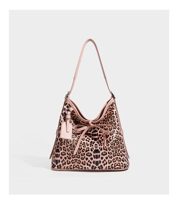Slouchy leopard print shoulder hobo bag with black leather-look trim, tie-top closure, and single long strap, detail view 13