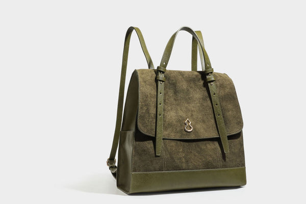 Structured suede-look convertible backpack handbag with flap closure and gold-tone emblem hardware in chocolate brown, detail