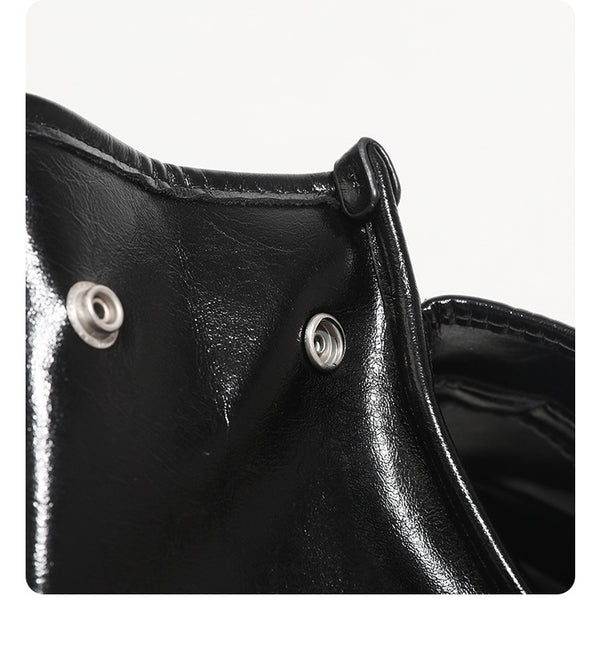 Structured glossy leather-look flap backpack handbag with dual buckle closures, top handle, and silver-tone hardware, detail