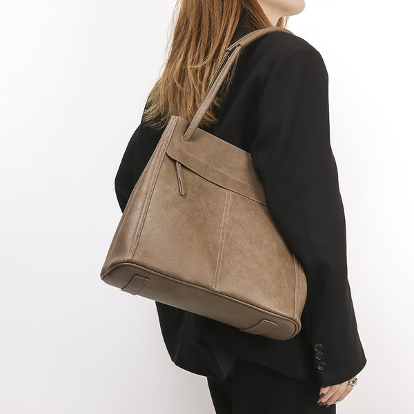 Retro structured matte leather-look tote bag in camel with front flap pocket, tassel pull, and double top handles, detail