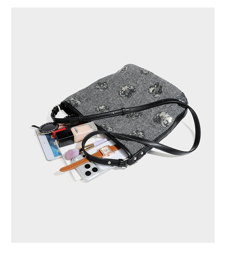 Lässig fallende Hobo-Schultertasche aus anthrazitfarbenem Webstoff mit floraler Stickerei aus silberfarbenen Pailletten, schwarzem Besatz in Lederoptik und langem