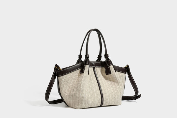 Cremefarbene geflochtene Tote-Bag mit dunkelbraunen Besätzen in Lederoptik, kontrastierenden weißen Nähten, zwei oberen Henkeln und abnehmbarem Schulter