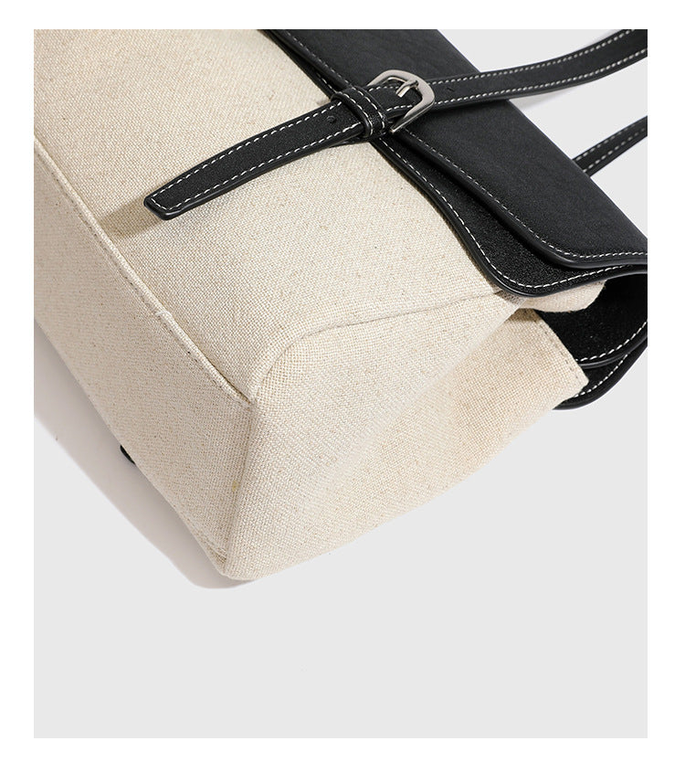 Strukturierte zweifarbige Schultertasche mit Klappe in schwarzer Lederoptik, cremefarbenem Körper mit Webstruktur, silberfarbenem Drehverschluss und doppeltem