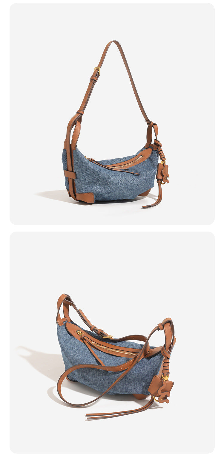 Washed denim canvas crescent hobo bag with tan leather-look trim, knotted strap detail, and gold-tone zipper hardware, detail