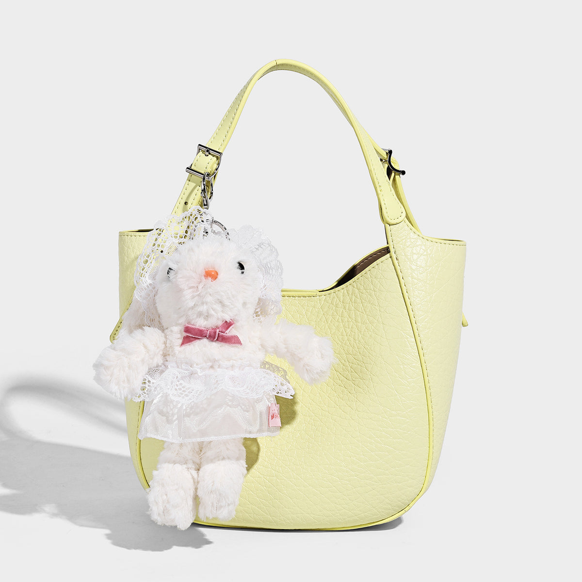 Small pebbled half-moon shoulder bag with dual top handles, detachable crossbody strap, and silver-tone hardware, detail view