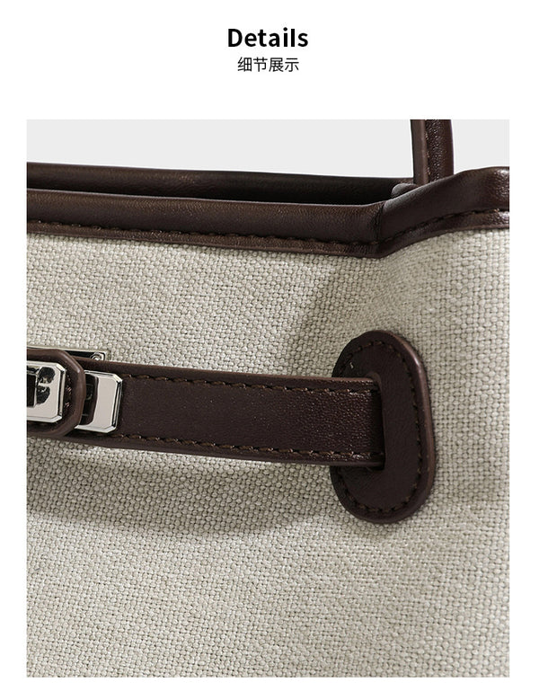 Small structured beige canvas top-handle bag with dark brown leather-look trim, silver turn-lock hardware, and detachable