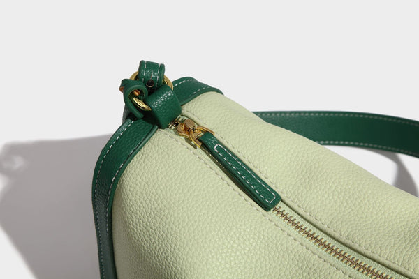 Structured two-tone shoulder bag with pebbled leather-look finish, contrast trim, top zip closure, and gold-tone hardware