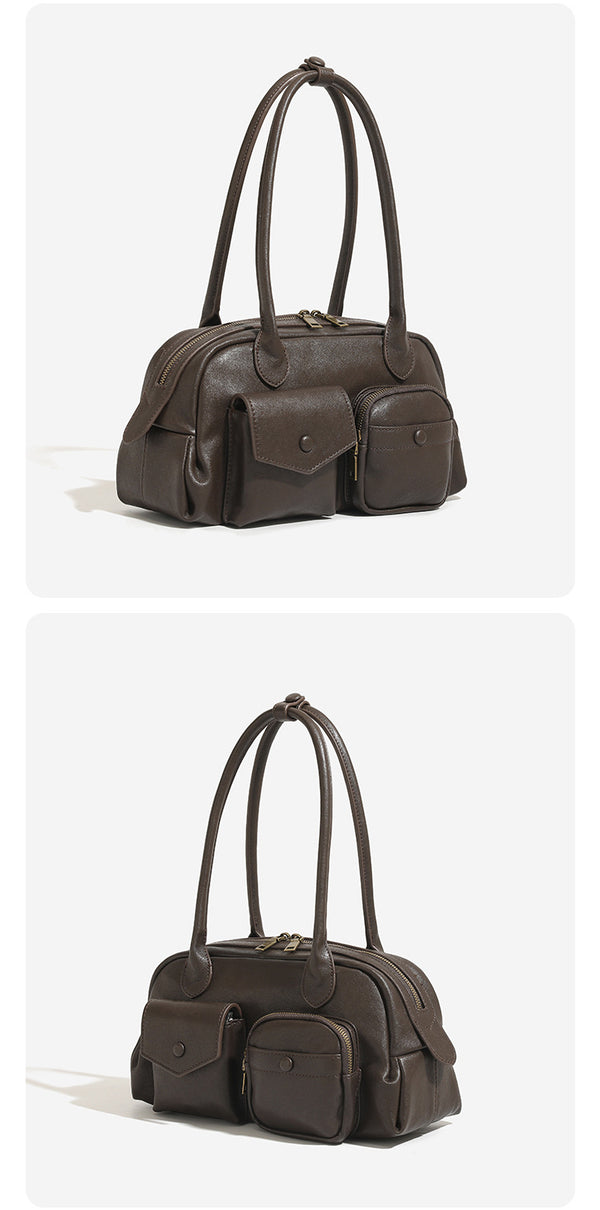 Structured matte leather-look bowling bag with snap-flap and zip front pockets, looped top handles, and antique gold-tone