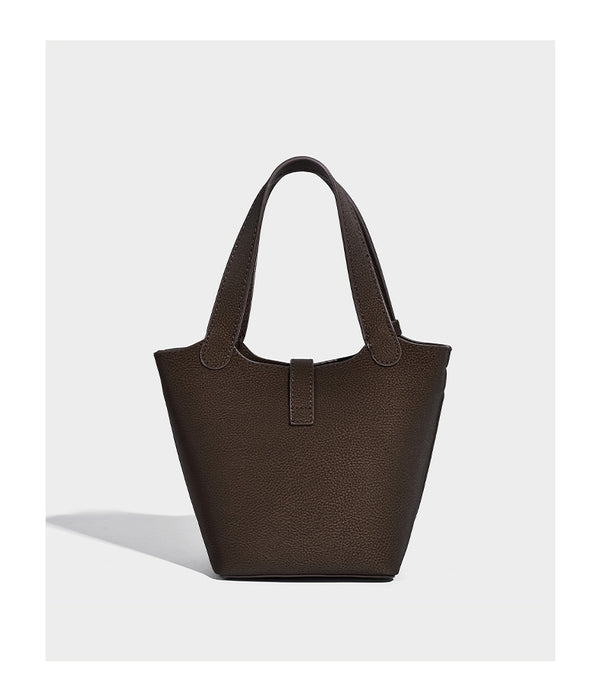 Kleine matte Beuteltasche mit genarbter Oberfläche, antikgoldfarbenen Ringbeschlägen, Perlen- und Quastenanhänger, kurzen Tragegriffen oben und