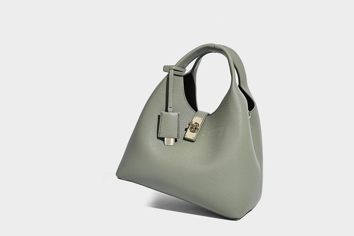 Structured pebbled-texture bucket bag with arched top handles, gold-tone turn-lock closure, and detachable shoulder strap