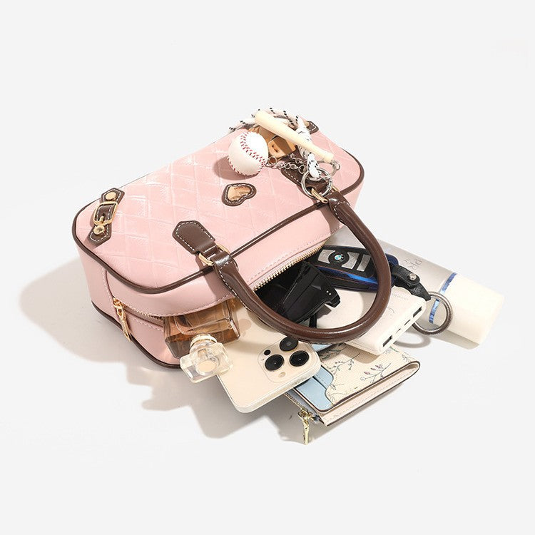 Small structured blush pink quilted diamond Boston barrel bag with brown leather-look trim, double top handles, heart accent