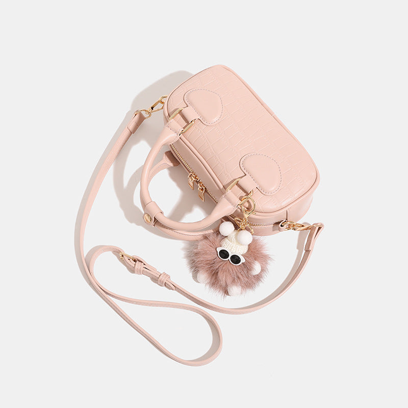Mini croc-embossed barrel handbag with gold-tone hardware, dual zip top handles, detachable crossbody strap, and fluffy