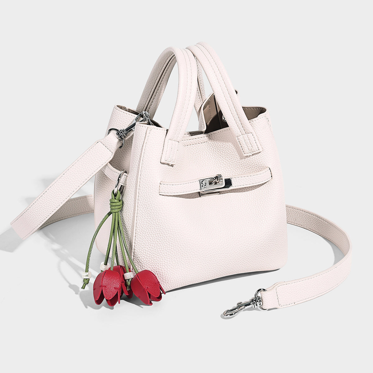 Small structured pebbled bucket tote bag with dual top handles, silver turn-lock front pocket, and detachable shoulder strap
