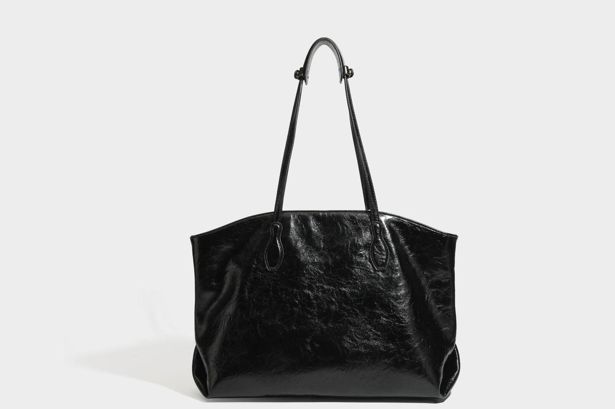 Übergroße, lässig fallende Tote-Bag aus glänzendem, geknittertem Lederimitat in dunklem Burgunderrot mit zwei langen Schulterriemen und kontrastierendem