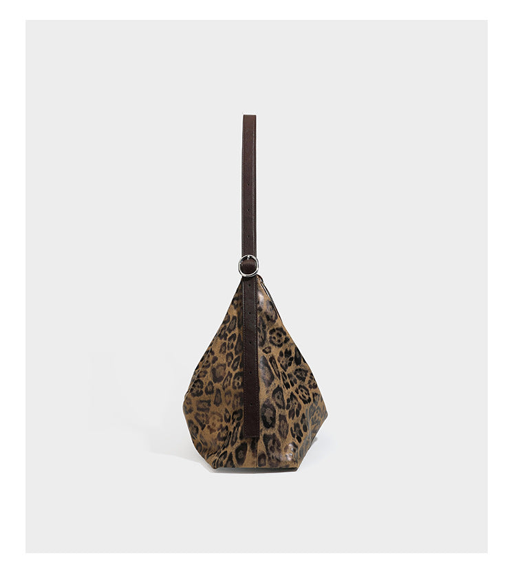 Slouchy leopard print hobo shoulder bag with glossy coated finish, top zipper closure, dark brown trim, and dangling charm