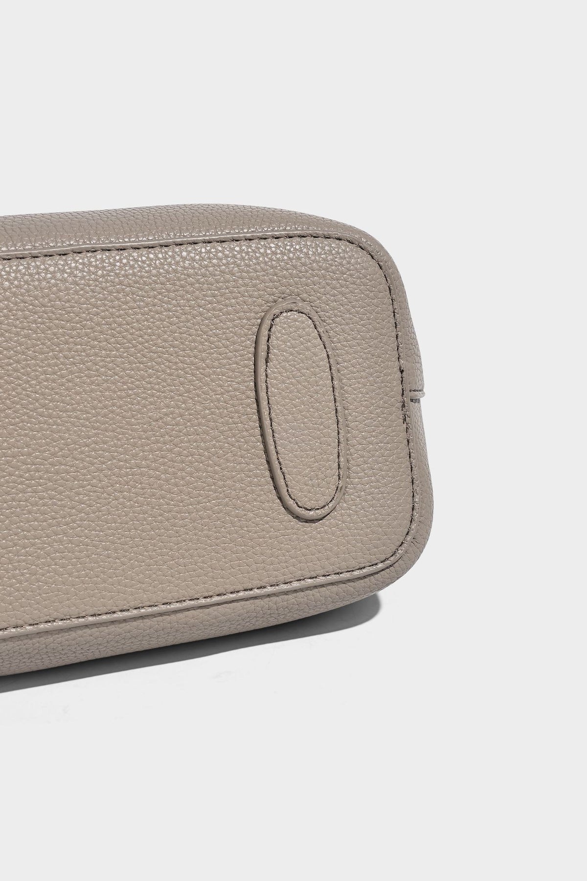 Kleine strukturierte Henkeltasche mit genarbter Oberfläche in Taupe, zwei Tragegriffen, bedrucktem Schalband, Drehverschluss an der Vorderseite und, Detail