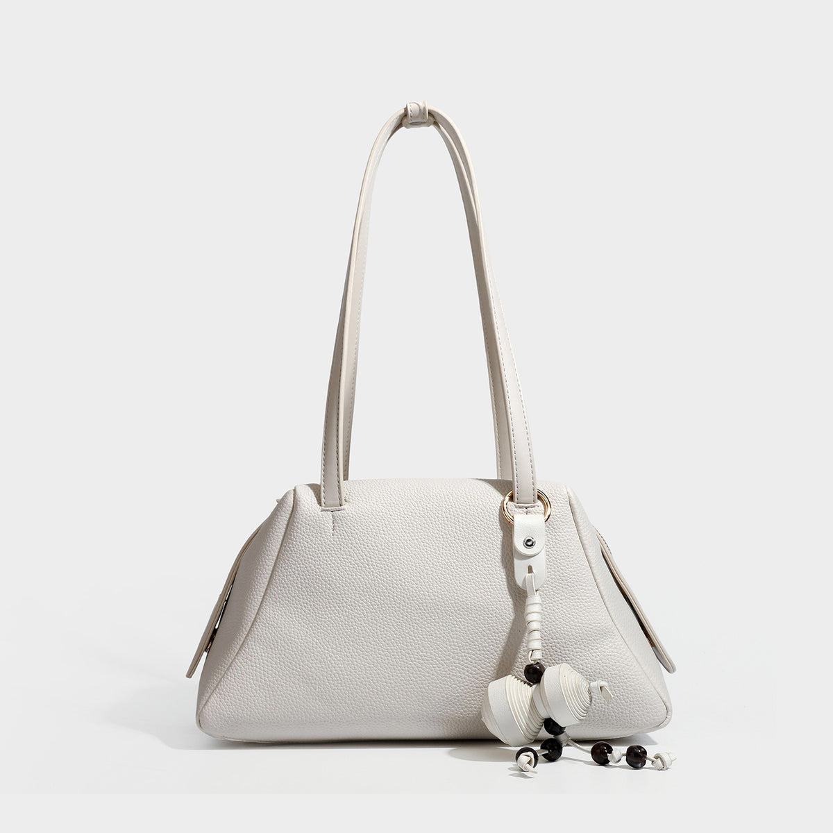 Structured trapezoid shoulder bag in dark brown pebbled leather-look finish with slim double straps, top zip closure, side