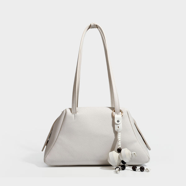 Structured trapezoid shoulder bag in dark brown pebbled leather-look finish with slim double straps, top zip closure, side