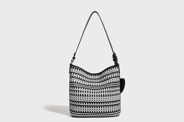 Woven stripe bucket shoulder bag in cream and dark brown with leather-look trim, knotted adjustable strap, and small shield
