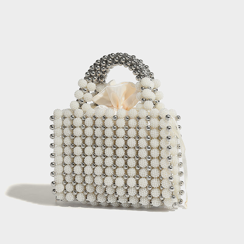 Small boxy pearl-bead mini top-handle bag with silver metallic bead accents, satin floral detail, and long beaded shoulder